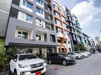 a row of cars parked in front of a building at Cozy At 9 Hotel And Kitchen in Bangkok