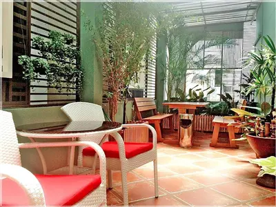 a patio with chairs and tables and plants at Cozy At 9 Hotel And Kitchen in Bangkok