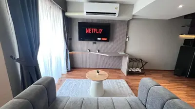a living room with a couch and a tv at We Hotel in Ban Bang Toei (1)