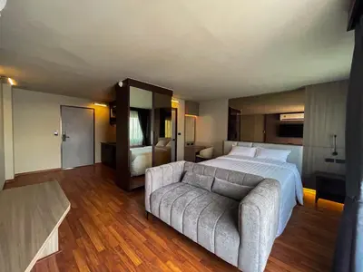 a large bedroom with a bed and a couch at We Hotel in Ban Bang Toei (1)