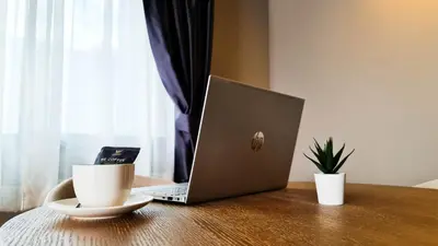 a laptop computer sitting on a wooden table with a cup of coffee at We Hotel in Ban Bang Toei (1)