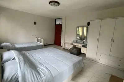 a bedroom with two beds and a mirror at Manoo House E in Pratunam