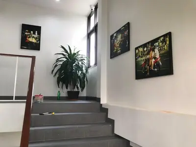 a staircase with pictures on the wall and a plant at Manoo House E in Pratunam