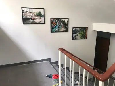 a staircase with four pictures on the wall at Manoo House E in Pratunam