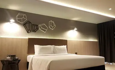 a bedroom with a bed and two lights on the wall at The Heritage Silom Hotel in Bangkok