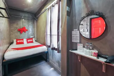 a small room with a bed and a mirror at Vm1 Hostel in Bangkok