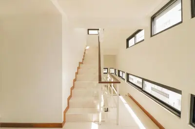 a staircase in a house with white walls and windows at OYO 225 Premier Place Bangkok in Bangkok