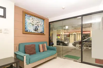 a room with a blue couch and a painting on the wall at OYO 225 Premier Place Bangkok in Bangkok