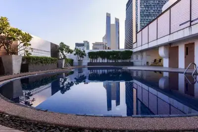 a large swimming pool in the middle of a building at Central 2BR 3 min walk from BTS Ploen Chit in Makkasan