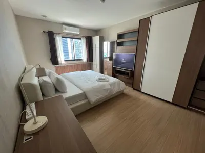 a hotel room with a bed and a television at Central 2BR 3 min walk from BTS Ploen Chit in Makkasan