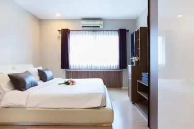 a bedroom with a large bed with a window at Central 2BR 3 min walk from BTS Ploen Chit in Makkasan