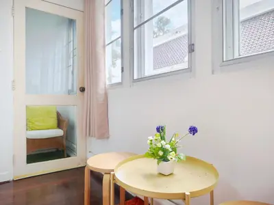 a room with two tables and a window at Maya Suite in Pratunam