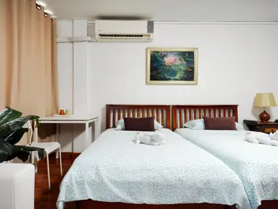 a bedroom with two beds with stuffed animals on them at Maya Suite in Pratunam