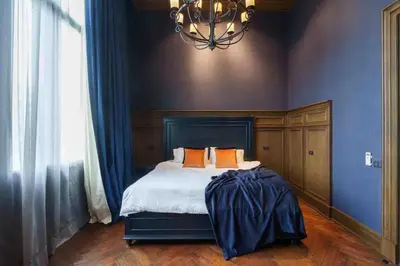 a bedroom with a bed with blue walls and a chandelier at Luxury Pool Villa with Jacuzzi & Lift by Thonglor in Bangkok