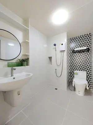 a white bathroom with a sink and a toilet at Joyful room in Ban Song Hong