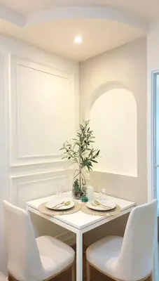 a white dining room with a table and chairs at Joyful room in Ban Song Hong