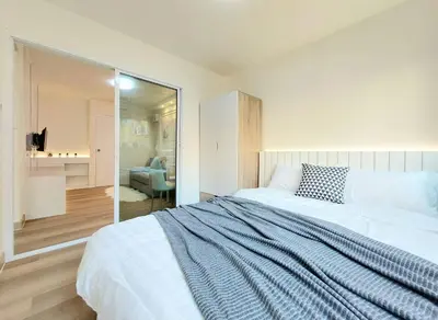 a bedroom with a large white bed and a mirror at Joyful room in Ban Song Hong
