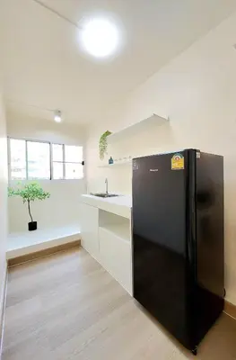 a kitchen with a black refrigerator in a room at Joyful room in Ban Song Hong