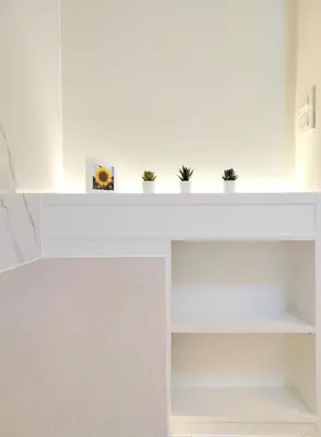 a white shelf with potted plants on it at Joyful room in Ban Song Hong