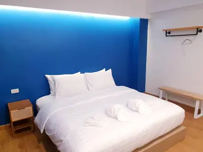 a large white bed with two towels on it at Blue Da Bed บลูด้าเบด in Ban Khlong Khwang Klang