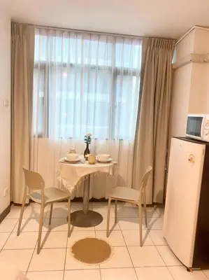 a kitchen with a table and chairs and a window at Jo Hometel in Lak Si