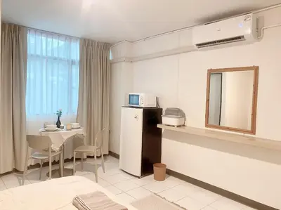 a room with a table and a mirror and a microwave at Jo Hometel in Lak Si