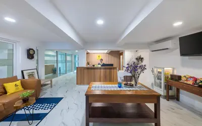 a living room with a table and a kitchen at Lee's Mark in Samutprakarn