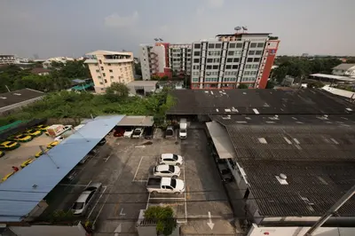 a parking lot with parked cars in a city at Lee's Mark in Samutprakarn