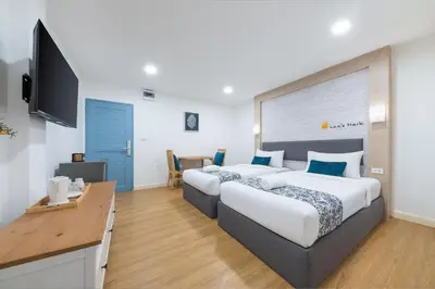 a hotel room with two beds and a television at Lee's Mark in Samutprakarn