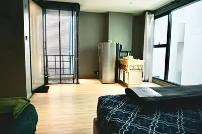 a room with a refrigerator and a wooden floor at Triple room at Hash Apartment Silom Soi 3 in Bangkok