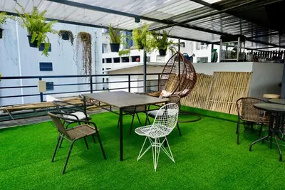 a patio with a table and chairs on grass at Triple room at Hash Apartment Silom Soi 3 in Bangkok