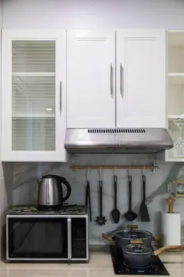 a kitchen with a microwave and a stove with utensils at BKK Sukumvit71 1 Bed 2 Bath 1 Living 1 Kitchen in Bangkok