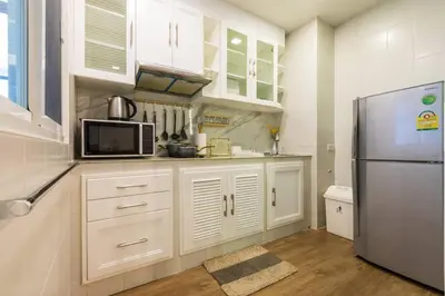 a kitchen with white cabinets and a refrigerator at BKK Sukumvit71 1 Bed 2 Bath 1 Living 1 Kitchen in Bangkok
