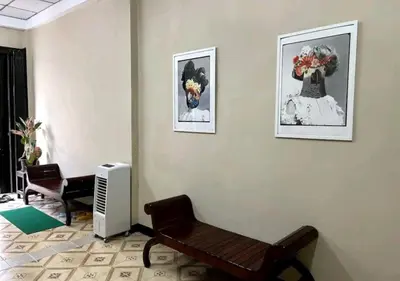 a living room with a bench and two pictures on the wall at DaHouse next to MRT Itsaraphap exit1 in Bangkok Yai