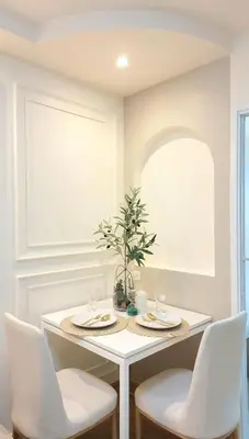 a white dining room with a table and chairs at Joyful room in Ban Song Hong