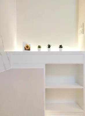 a white shelf with potted plants on it at Joyful room in Ban Song Hong