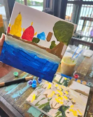 a person holding up a painting of a painting of a painting at เฉื่อย โฮมสเตย์ in Nonthaburi