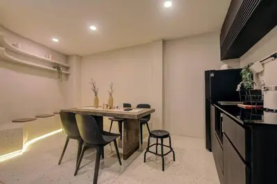 a kitchen with a table and chairs in a room at Potji's private apartment in Bang Su
