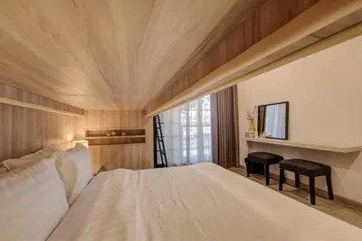a bedroom with a large white bed and a desk at Potji's private apartment in Bang Su