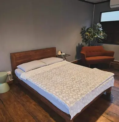 a bedroom with a bed and a couch and a chair at เฉื่อยโฮมสเตย์ in Nonthaburi