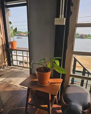 a plant sitting on a table next to a chair at เฉื่อยโฮมสเตย์ in Nonthaburi
