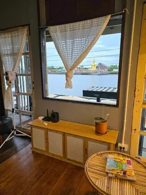 a room with a large window with a view of the water at เฉื่อยโฮมสเตย์ in Nonthaburi
