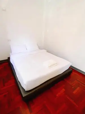 a white bed in a room with a wooden floor at XX GO INN BTS Surasak Silom bkk โกอินน์ บีทีเอส สถานีสุรศักดิ์ in Yan Nawa