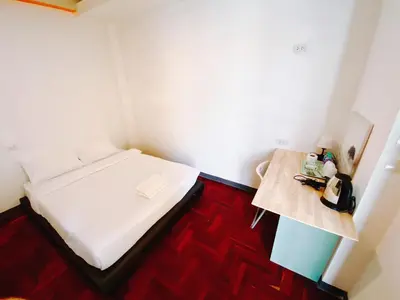 a small room with a bed and a table at XX GO INN BTS Surasak Silom bkk โกอินน์ บีทีเอส สถานีสุรศักดิ์ in Yan Nawa