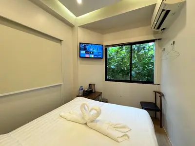 a bedroom with a bed with two towels on it at AVALAN PhayaThai airport link in Pratunam