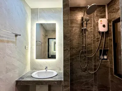 a bathroom with a sink and a shower at AVALAN PhayaThai airport link in Pratunam