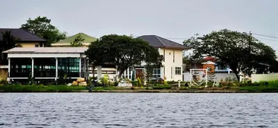 a house on the shore of a body of water at Tiny Island Lake Lodge in Bangkok
