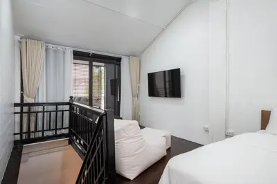 a bedroom with a bed and a balcony with a tv at 499 House Villa in Bangkok