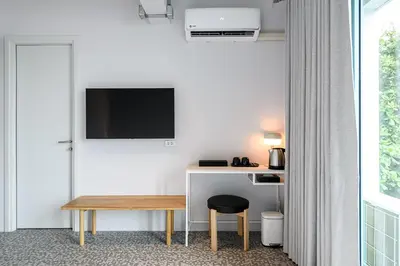 a room with a desk with a television and a stool at Mowa Bangkok in Bangkok