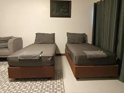 two twin beds in a room with curtains at Popular Muang Thong Thani Condo, Building T9, Floor 4, Room 36 in Thung Si Kan